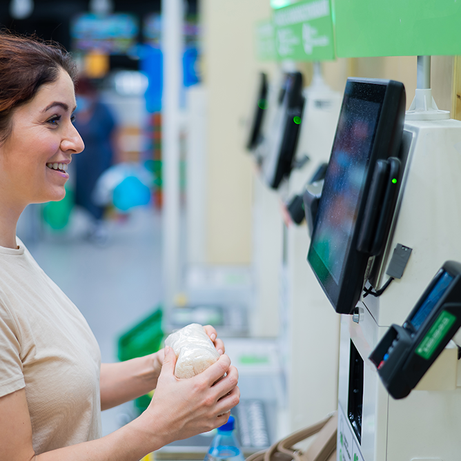 Cliente usando una terminal de autoservicio en retail